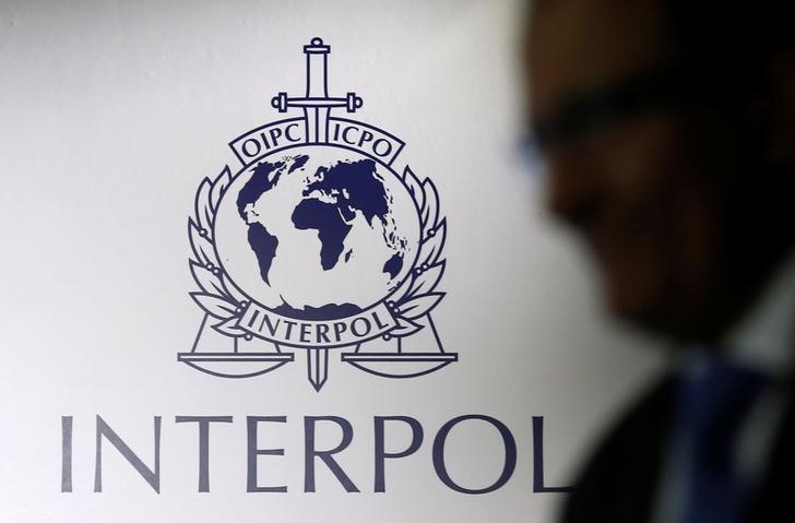 © Reuters. A man passes an Interpol logo during the handing over ceremony of the new premises for Interpol's Global Complex for Innovation in Singapore