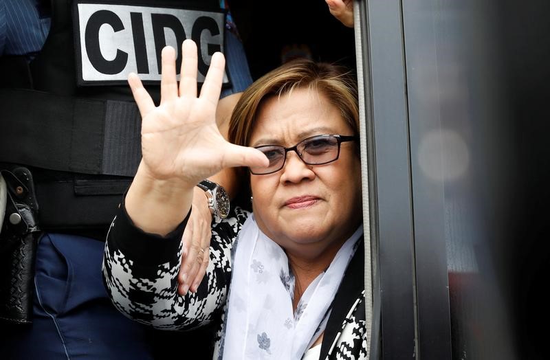 © Reuters. FILE PHOTO: Philippine Senator Leila De Lima waves from a police van after appearing at a Muntinlupa court on drug charges in Muntinlupa, Metro Manila