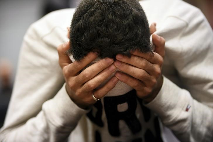 © Reuters. The 18-year-old Moroccan Ilyas Berrouh,  covers his face during the initial remand hearing of suspects of killing two people and attempting to kill eight others with terrorist intent, at the Southwest Finland District Court in Turku