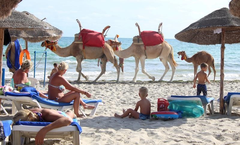 © Reuters. Tourists relax on a beach on the island of Djerba