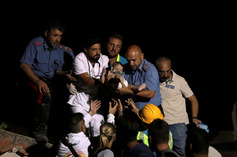 © Reuters. Socorristas carregam um bebê depois que um terremoto atingiu a ilha de Ischia, na Itália