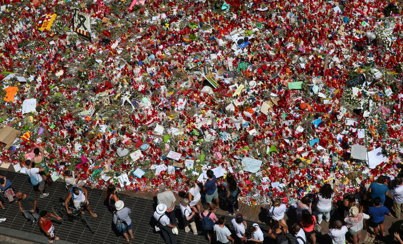 © Reuters. Pessoas se reúnem com flores em local onde van atropelou pedestres em Las Ramblas, Barcelona