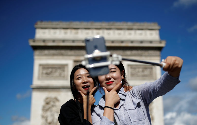 © Reuters. Turistas tiram foto em frente ao Arco do Triunfo, na avenida Champs-Élysées, em Paris