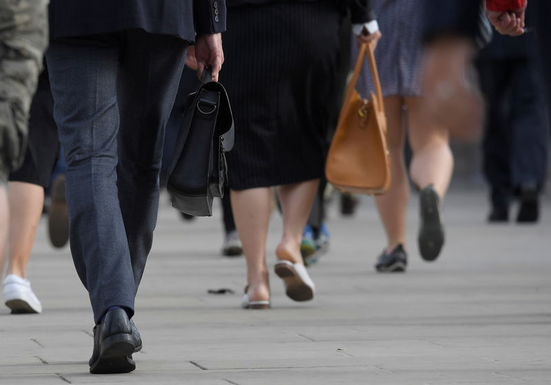 © Reuters. FILE PHOTO - Workers cross London Bridge during the morning rush hour in London