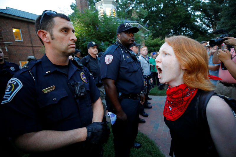 © Reuters. A protester yells at a policeman after violence erupted at a demonstration against a statue of a Confederate soldier nicknamed Silent Sam on the campus of the University of North Carolina in Chapel Hill