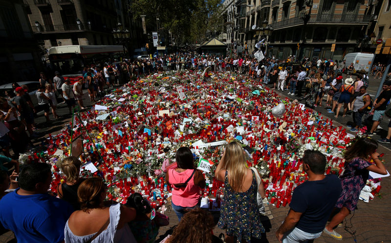 © Reuters. People gather at an impromptu memorial at the site where a van crashed into pedestrians at Las Ramblas in Barcelona