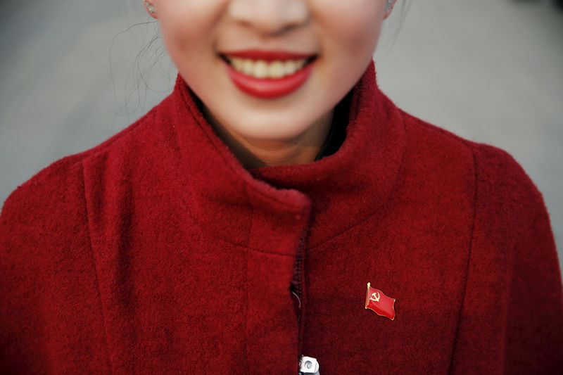 © Reuters. FILE PHOTO - A hostess wears a pin of China's Communist Party flag ahead of the closing ceremony of National People's Congress at the Great Hall of the People in Beijing