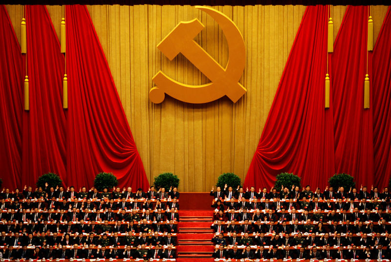 © Reuters. FILE PHOTO - A general view shows delegates raising their hands as they take a vote at the closing session of the 18th National Congress of the Communist Party of China at the Great Hall of the People in Beijing