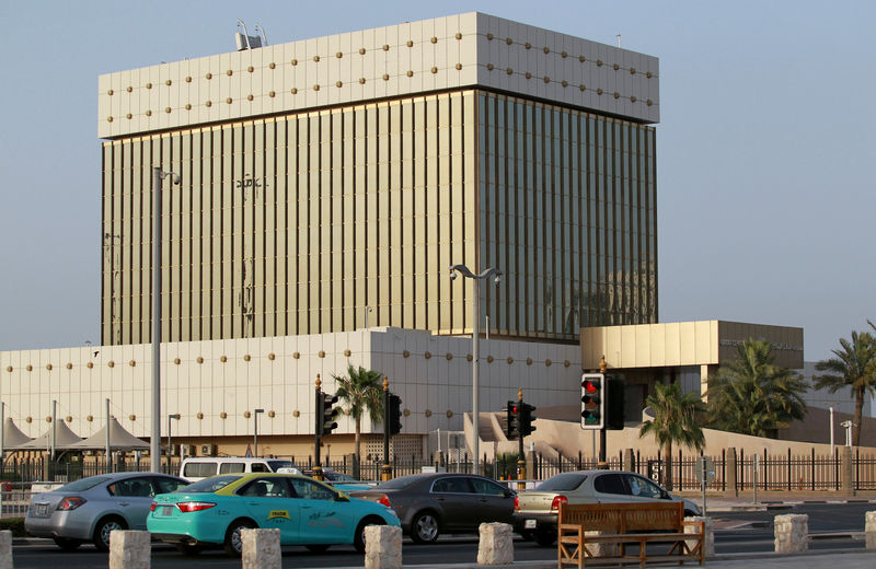 © Reuters. FILE PHOTO: Cars drive past the building of Qatar Central Bank in Doha