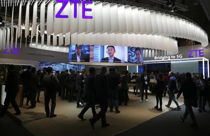 © Reuters. People stand at ZTE's booth during Mobile World Congress in Barcelona
