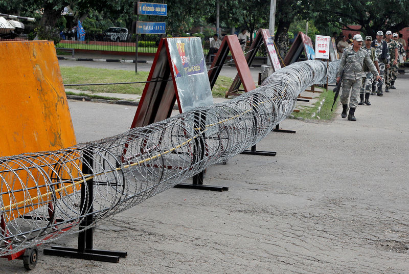 © Reuters. Police patrol next to concertina wire barricade outside a court in Panchkula