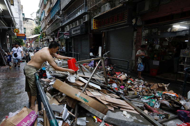 © Reuters. Homem limpa loja atingida pelo tufão Hato, em Macau