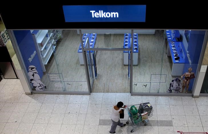 © Reuters. A shopper walks past a Telkom shop at a mall in Johannesburg
