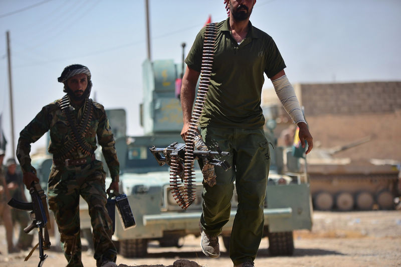 © Reuters. Shi'ite Popular Mobilization Forces (PMF) members carry there wepons at Al Jazeera neighbourhood of Tal Afar