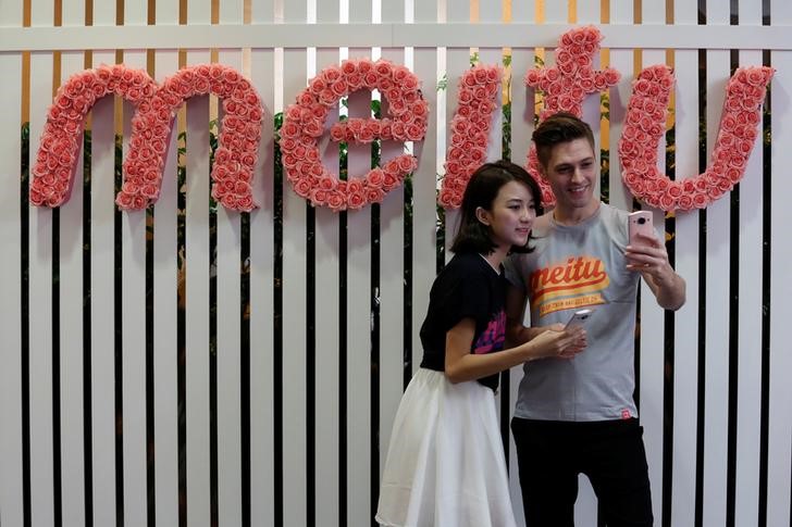 © Reuters. Modelos tiram selfie durante confêrencia com jornalistas sobre IPO da Meitu em Hong Kong, China