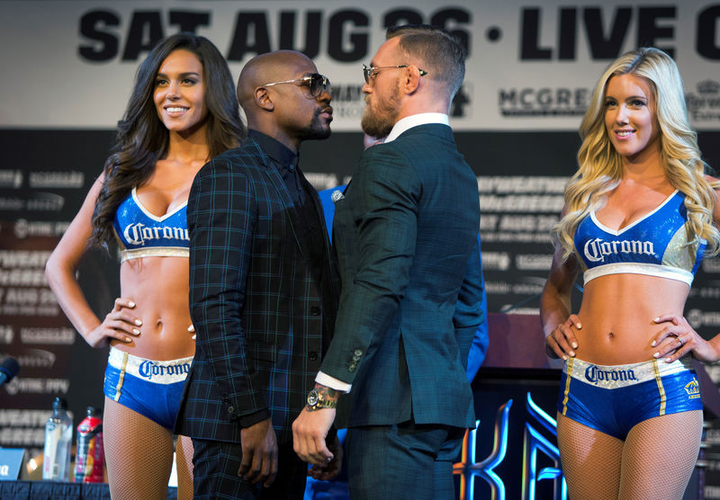 © Reuters. Undefeated boxer Floyd Mayweather Jr. (L) of the U.S. and UFC lightweight champion Conor McGregor of Ireland face off during a news conference in Las Vegas