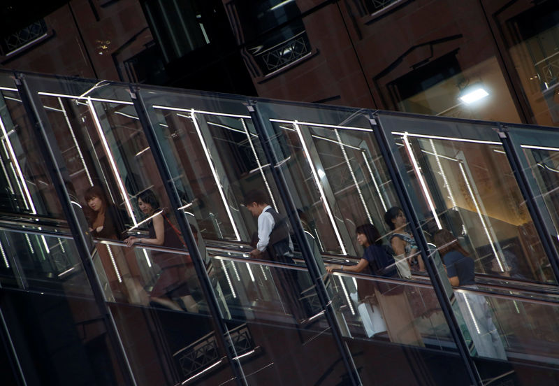 © Reuters. Shopppers ride an escalator to a shopping mall in Tokyo