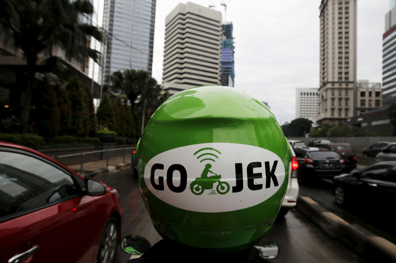© Reuters. FILE PHOTO: A Gojek driver rides his motorcycle through a business district street in Jakarta