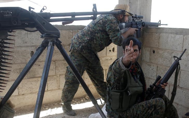 © Reuters. A Kurdish fighter from the People's Protection Units (YPG) gestures during a battle with Islamic State militants in Raqqa