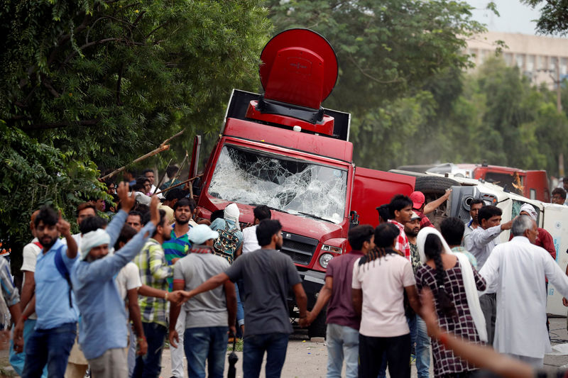 © Reuters. Manifestantes atacam van de televisão durante protesto em Panchkula, na Índia