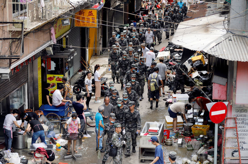 © Reuters. Soldados do Exército de Libertação Popular da China passam por rua atingida pelo tufão Hato, em Macau