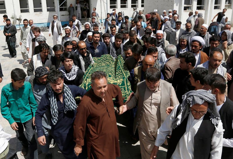 © Reuters. People carry the body of one of the victims of Friday's attack at a Shi'ite Muslim mosque, during a burial ceremony, in Kabul