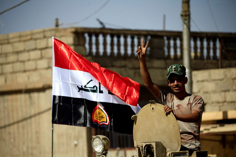 © Reuters. A member of Shi'ite Popular Mobilization Forces (PMF) flags victory sign during clashes against the Islamic State militants in Tal Afar