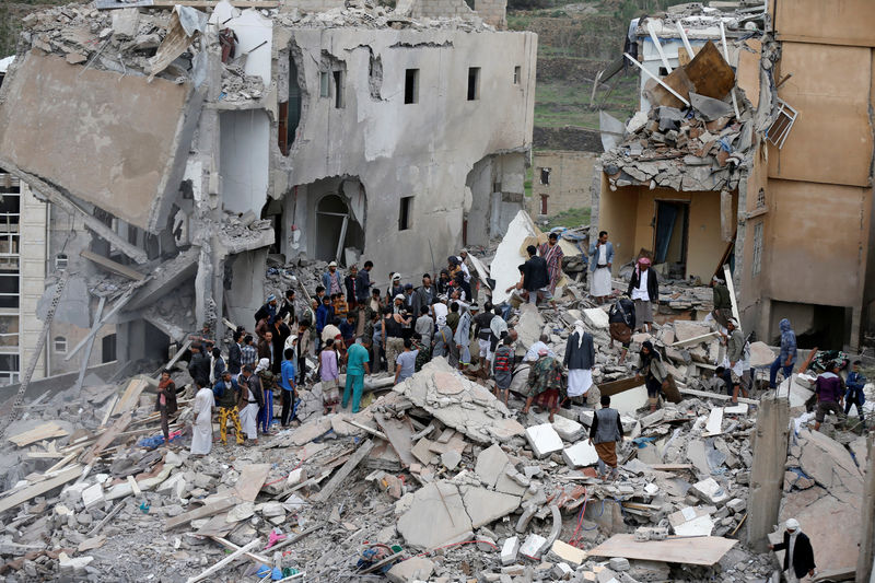 © Reuters. People search under the rubble of a house destroyed by a Saudi-led air strike in Sanaa