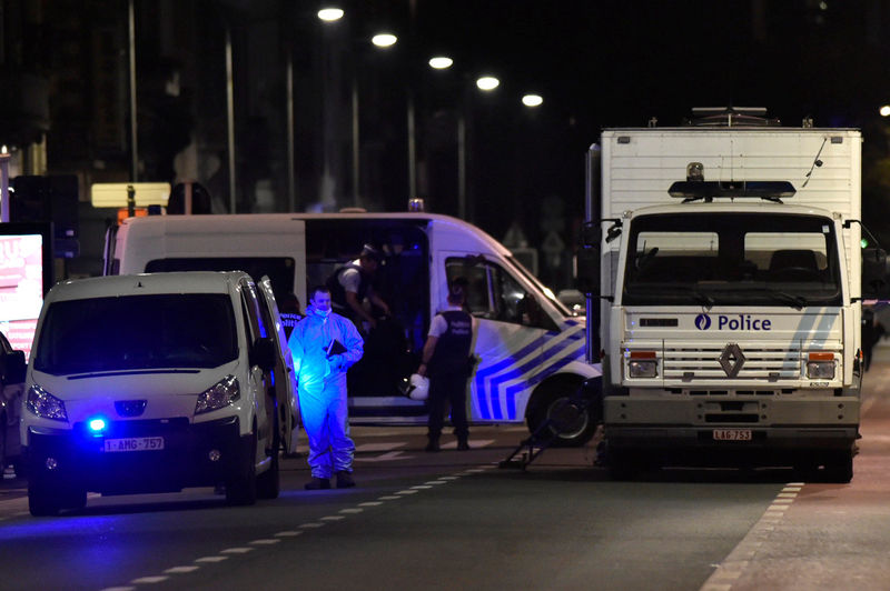 © Reuters. Policemen stand on the scene after Belgian soldiers shot a man who attacked them with a knife, in Brussels