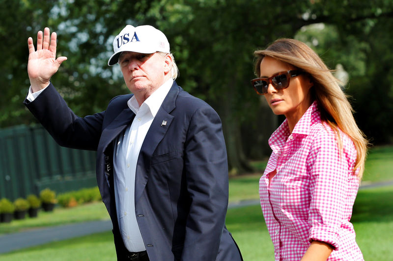 © Reuters. President Donald Trump waves as he walks with first lady Melania Trump on South Lawn of the White House in Washington