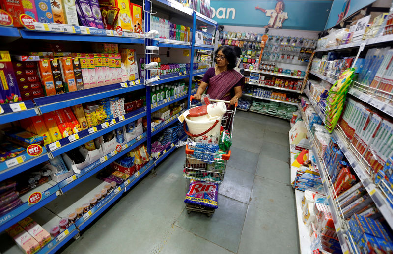 © Reuters. FILE PHOTO - A woman pushes a shopping trolley at a food superstore in Ahmedabad