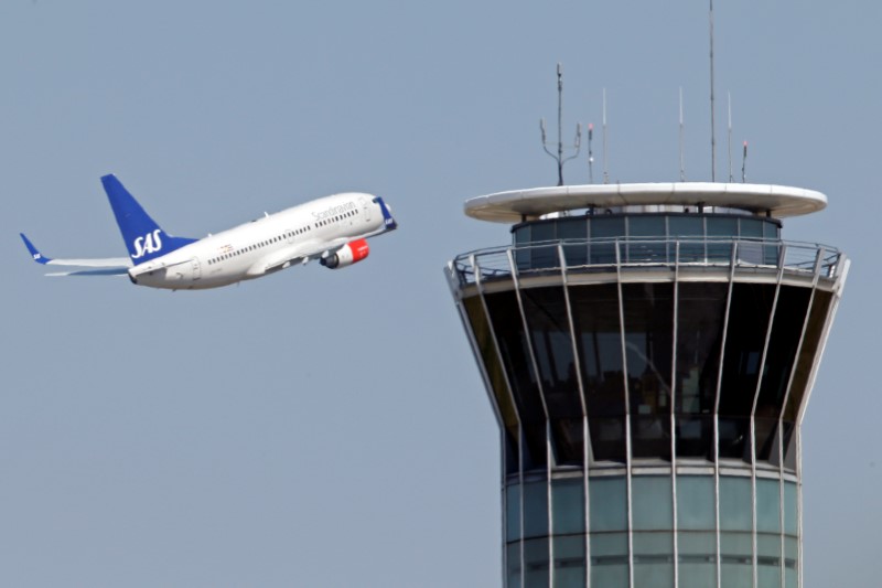 © Reuters. A Scandinavian SAS airline passenger plane flies near the air traffic control tower at Roissy airport, near Paris