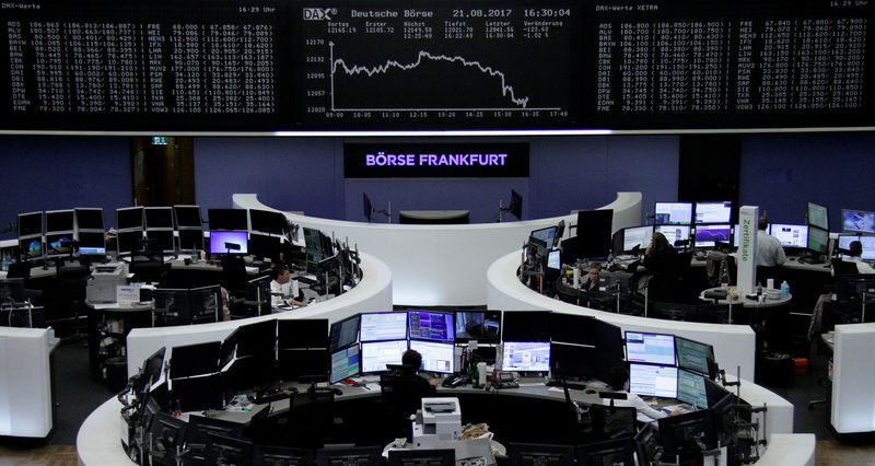 © Reuters. FILE PHOTO - Traders work in front of the German share price index, DAX board, at the stock exchange in Frankfurt