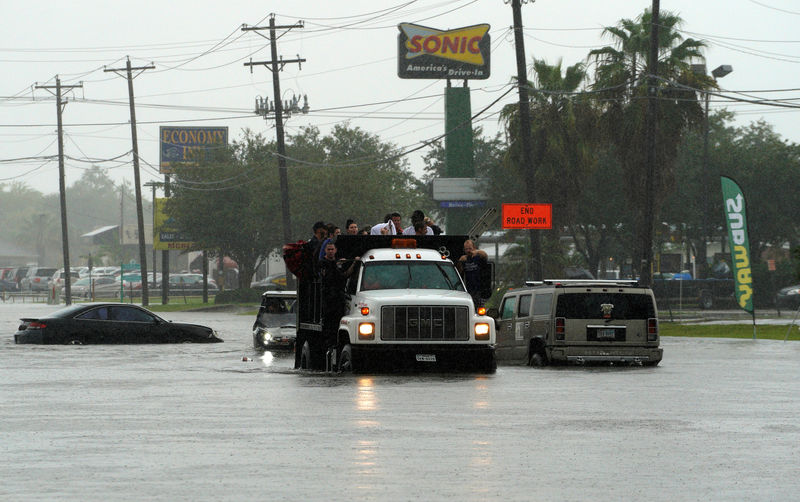 © Reuters. Люди эвакуируются из затопленного ураганом "Харви" города Дикинсон, Техас