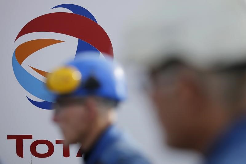 © Reuters. Funcionário passa por logo da petroleira francesa Total