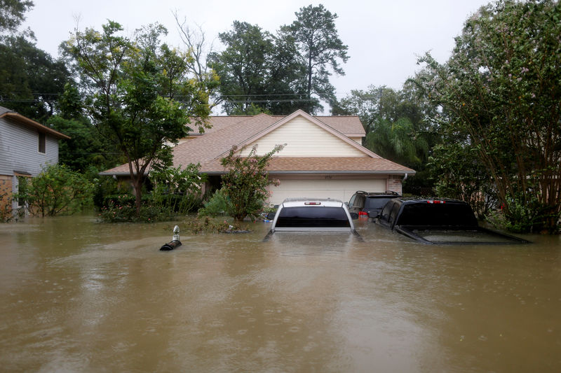 © Reuters. Casa e carros parcialmente submersos por enchentes em Houston