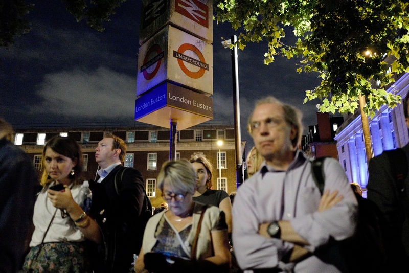 © Reuters. Commuters are seen outside Euston Station after police evacuated the area following a security alert, in London