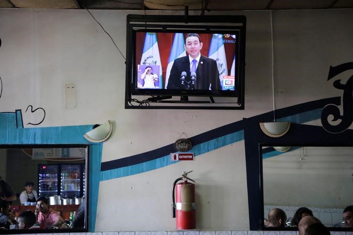 © Reuters. Una transmisión por televisión de un discurso del presidente de Guatemala, Jimmy Morales, en un restaurante en Ciudad de Guatemala