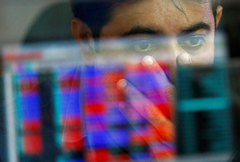 © Reuters. FILE PHOTO: A broker reacts while trading at his computer terminal at a stock brokerage firm in Mumbai