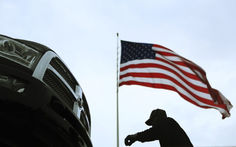 © Reuters. An auto carrier driver unloads a new Ram pickup truck in Gaithersburg, Maryland