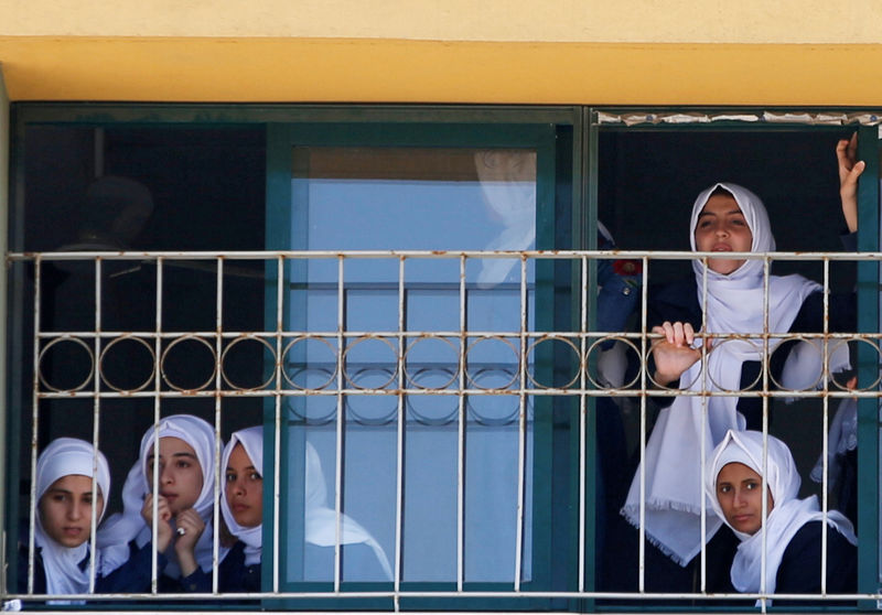 © Reuters. Palestinian school girls look out of their classroom during a visit by United Nations Secretary-General Guterres at UN-run school in the northern Gaza Strip