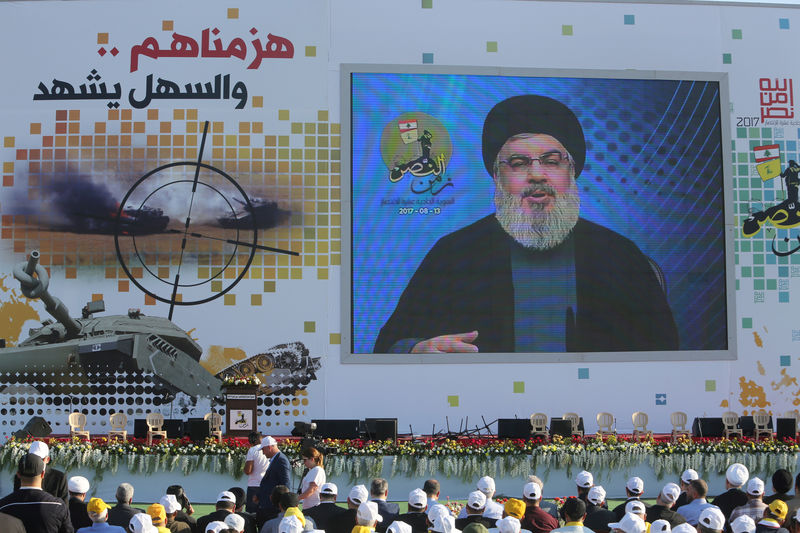 © Reuters. FILE PHOTO - Lebanon's Hezbollah leader Sayyed Hassan Nasrallah speaks via a screen during a rally marking the 11th anniversary of the end of Hezbollah's 2006 war with Israel, in the southern village of Khiam