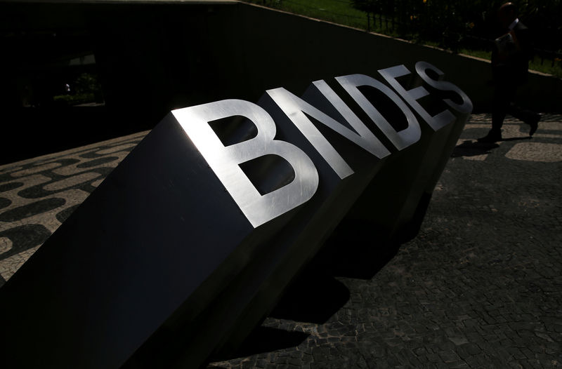 © Reuters. FILE PHOTO: Man walks past the logo of Brazilian Development Bank (BNDES) at the entrance of its headquarters in Rio de Janeiro