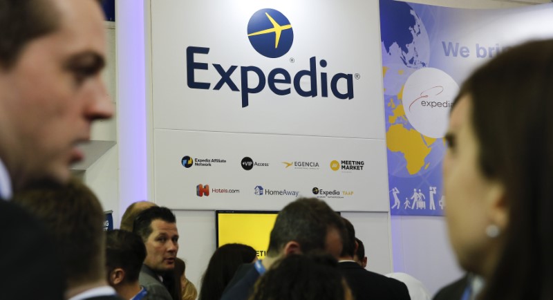 © Reuters. FILE PHOTO - Visitors browse at the stand of global online travel brand Expedia during the International Tourism Trade Fair in Berlin