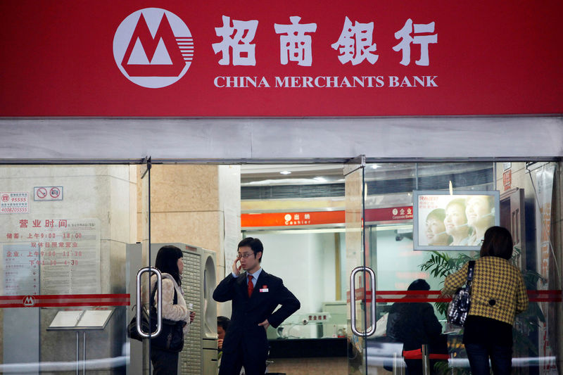 © Reuters. FILE PHOTO: People stand at a branch of China Merchants Bank in Shanghai