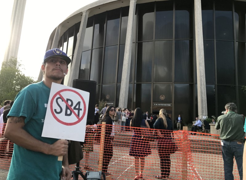 © Reuters. FILE PHOTO: A protester against the Texas state law to punish "sanctuary cities" stands outside the U.S. Federal court in San Antonio