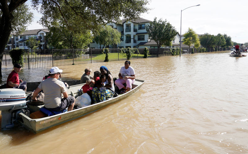 © Reuters. Una familia es evacuada en bote tras resultar afectada por la tormenta tropical Harvey en Houston, EEUU