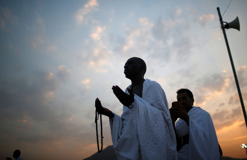 © Reuters. حجاج يتلمسون عطر النبي محمد فوق جبل الرحمة