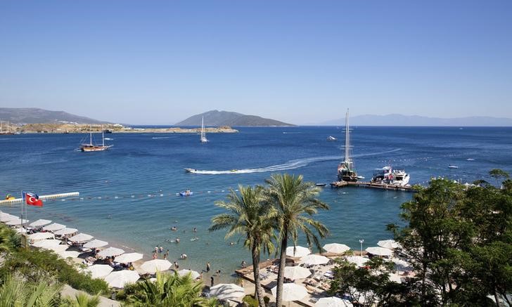 © Reuters. Holidaymakers rest at a beach in the resort town of Bodrum