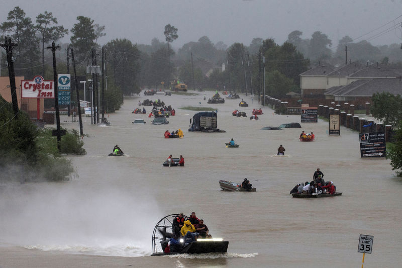 © Reuters. Moradores usam barcos em uma rodovia alagada pela tempestade tropical Harvey em Houston, no Texas